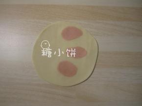 白色面剂子压扁，上面随意点缀几小团红色剂子，一起擀成饺子皮