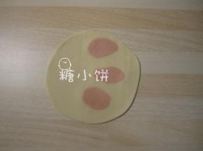 白色面剂子压扁，上面随意点缀几小团红色剂子，一起擀成饺子皮
