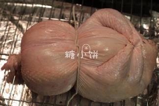 鸡翅回塞到胸腔里。用绳子扎住脖子处的开口。
中间也用绳子扎一下，葫芦的形状就出来了。这张图是反面的样子。
我不知道人家饭店里是怎么造型的哈，没吃过，只搜到几张网图看不出所以然来。
鸡翅部分塞回胸腔内是我自己试出来觉得最好看的方法了。