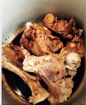 把骨头铺满高压锅底，将酱汁倒入。此时开火