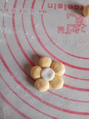 将五个南瓜面团合成花朵型，中间放一个白色面团