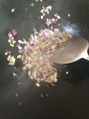 锅内倒油，加入葱白，洋葱翻炒变色