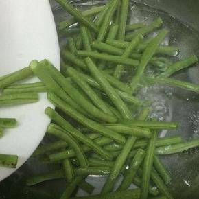 汤锅里加入适量的水、盐和油烧开，然后将长豆角放入焯水十分钟左右