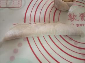 把饺子皮合起，从边上开始卷起，在收口处粘点水定型