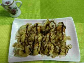 5、做好后，用签子挑到盘子中，挤上沙拉酱，撒上木鱼花，最后再挤上照烧酱。