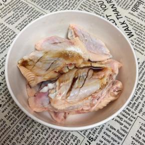 鸡翅洗净，在背面画两刀放入碗中，调入盐和鸡精，倒入酱油。