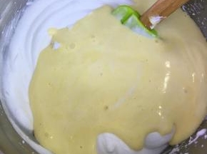 将拌好的蛋糕糊倒入到剩余的蛋白霜中，翻拌均匀。