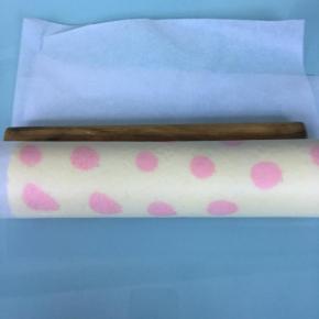 借助擀面棍将蛋糕卷起，用油纸包好，放入冰箱冷藏定型30分钟以上。