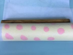 借助擀面棍将蛋糕卷起，用油纸包好，放入冰箱冷藏定型30分钟以上。