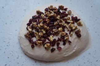 将蔓越莓碎和核桃碎的一半放在面团表面