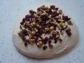 将蔓越莓碎和核桃碎的一半放在面团表面