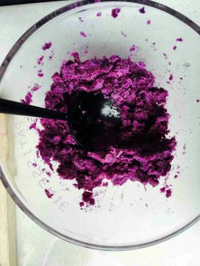 蒸熟的紫薯用勺子撵成泥。