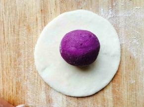 白色面团擀成片，紫薯球放上面。