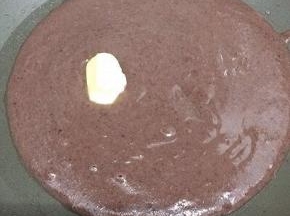 将打好的红豆泥倒入锅中，加入黄油搅均匀