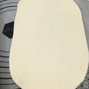 饧好的小面团用擀面杖擀成长方形，上面用刷子刷少许的油