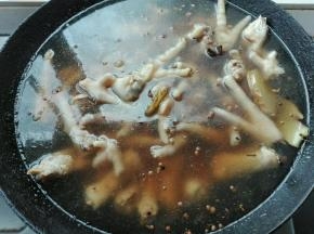 3. 水开后放入处理好的凤爪，倒入适量黄酒，盖上盖子烧开，揭开锅盖，继续烧开五分钟