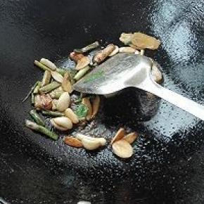 6. 将腌制鱼的葱姜蒜捞出，放入倒有底油的锅中炝锅