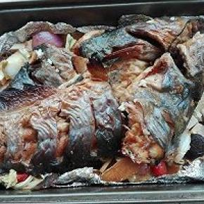 10. 将烤盘中的鱼取出，底下铺上一半炒过的菜料，再放入鱼