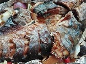 10. 将烤盘中的鱼取出，底下铺上一半炒过的菜料，再放入鱼