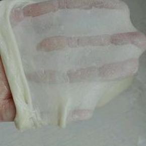 2. 将烫种同主面团除了黄油外全部混合揉至可以拉出大片厚膜，加入软化黄油，继续揉至扩展状态，如图所示