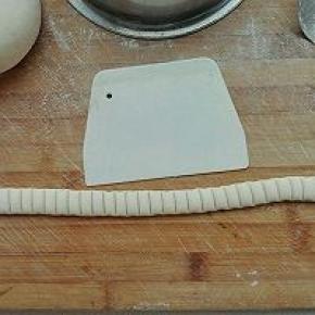 7. 将50克的面团搓成长条可以围住图五的长度，用刮板压出痕，如图所示