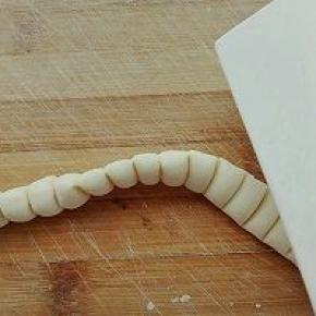 8. 继续将压好痕的长条竖起来，用刮板竖着压一下