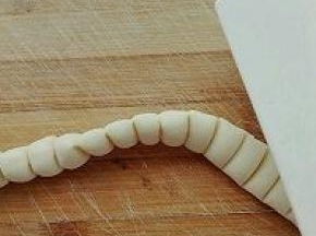 8. 继续将压好痕的长条竖起来，用刮板竖着压一下