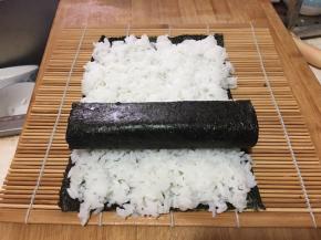 把卷好的海苔厚蛋烧放在米饭上。