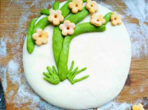 胡萝卜面团擀平，用花朵模具印出花朵形状抹水装饰到树上