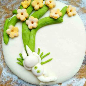 沾在面饼上小兔子依着树根进入梦乡，取一点绿色面团揉圆做纽扣，用牙签中间戳几下纽扣更逼真