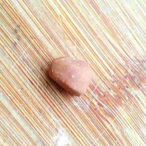 取白色面团加少许可可粉揉匀成可可面团，取一点捏成前头略窄，上边稍扁的乌龟头的形状，