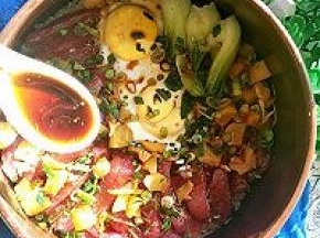 打开砂锅可以看到香肠熟透，鸡蛋也成型了。喜欢有锅巴的话，可以继续小火慢慢再焖五分钟。撒蒜葱花（撒了蒜花之后，可以再盖上盖子焖3-5秒；时间不能太长，不然蒜葱的颜色会变黄，就不好看了）均匀浇上调料汁，拌几下就可以吃啦。