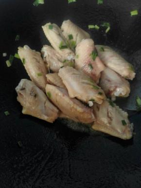 3、热锅热油加入葱花煸出香味下入中翅翻炒。