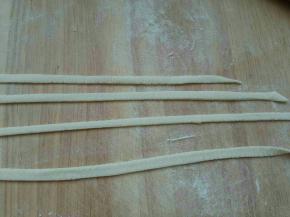 取一根面朝两头一边抻一边摔打成细长条。