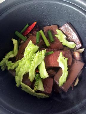 放入切好的苦瓜和葱段