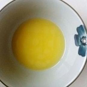 将黄油切小块，放入碗内，隔热水溶化成液态。