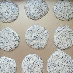 用汤匙挖少许的饼干面粉平铺在烤盘上，中间要留较大的位置以便摊平饼干。