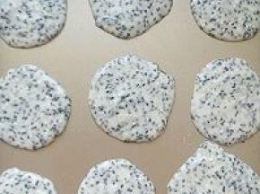 用汤匙挖少许的饼干面粉平铺在烤盘上，中间要留较大的位置以便摊平饼干。