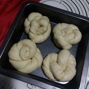 将相接的部分塞进圆圈里，表面是5个辫，排到涂过油的烤盘上，放温暖湿润处进行最后发酵。