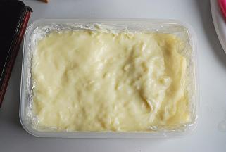 倒入之前铺好椰蓉的密封盒内，用力振几下，尽量使表面平整