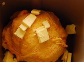 待面团能够拉出粗膜，放入软化的黄油，继续揉一个程序，约20分钟，至面团能拉出透明的手套膜状态