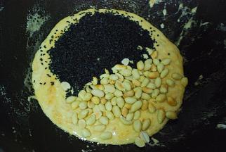 快速倒入熟芝麻与去皮熟花生