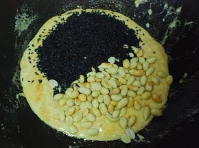 快速倒入熟芝麻与去皮熟花生