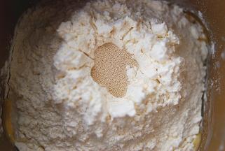 将主料中除黄油以外的所有材料，放入面包机中，加入做好的汤种，搅拌成光滑的面团