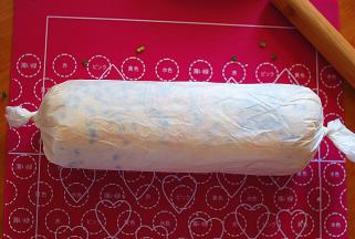 借助擀面杖，将面包片卷起来，用油纸裹紧，放置30分钟定型