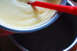 从冰箱里取出蛋糕模具，倒入一半的芒果糊