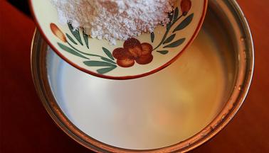 将淡奶油倒入奶锅中，加入20克糖粉