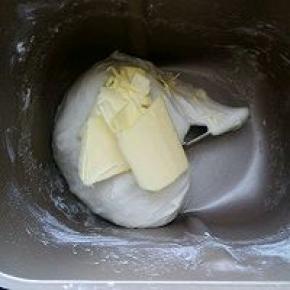 表面光滑后加入黄油继续揉，揉至扩展阶段