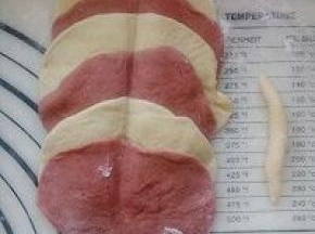 擀开成园片，原色一张彩色一张叠在一起，可以单数可以双数，随自己喜欢。中间用筷子压一下，取一小面团搓成长条当花蕊。