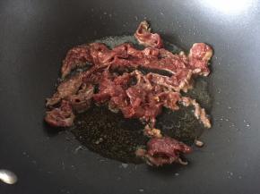锅里热油后放入腌制好的牛肉炒，炒好后装盘备用